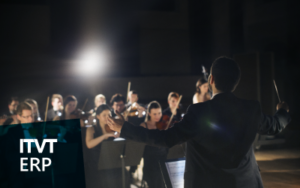Ein Dirigent, der wÃ¤hrend einer AuffÃ¼hrung ein Orchester leitet, wÃ¤hrend Musiker auf der BÃ¼hne verschiedene Instrumente spielen. Die Szene vermittelt Koordination, Harmonie und Teamwork. Das ITVT ERP-Logo erscheint in der unteren linken Ecke.