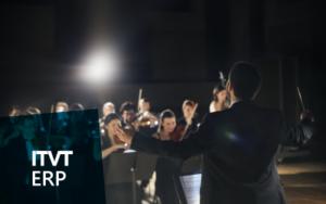 Ein Dirigent, der wÃ¤hrend einer AuffÃ¼hrung ein Orchester leitet, wÃ¤hrend Musiker auf der BÃ¼hne verschiedene Instrumente spielen. Die Szene vermittelt Koordination, Harmonie und Teamwork. Das ITVT ERP-Logo erscheint in der unteren linken Ecke.