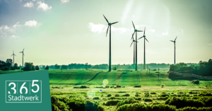 GrÃ¼ne Landschaft mit mehreren Windkraftanlagen unter strahlend blauem Himmel, Logo â€ž365 Stadtwerkâ€œ in der unteren linken Ecke.