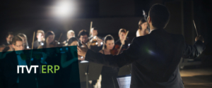 Ein Dirigent steht vor dem Publikum, den Taktstock in der Hand, und leitet leidenschaftlich das Orchester.