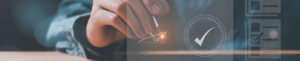 Eine Person hÃ¤lt einen Stift in der Hand und berÃ¼hrt einen Bildschirm, auf dem ein HÃ¤kchen erscheint, das die Fertigstellung oder Genehmigung anzeigt.