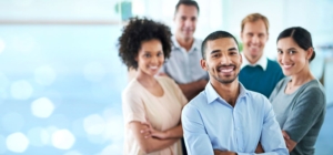 Ein Team von Personen in GeschÃ¤ftskleidung, die in einem BÃ¼ro stehen und in einer professionellen Umgebung zusammenarbeiten und Ideen austauschen.