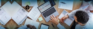 Eine heterogene Gruppe von Menschen, die an einem Laptop an einem Schreibtisch zusammenarbeiten, sich auf ihre Arbeit konzentrieren und Ideen austauschen.
