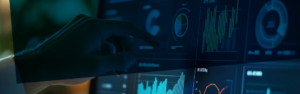 Eine Person zeigt auf einen Computerbildschirm, auf dem verschiedene Datenmetriken und Grafiken angezeigt werden.