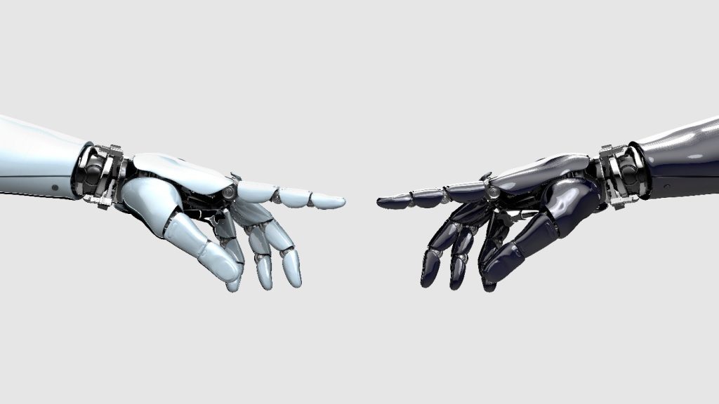 Zwei Roboterhände, die sich vor einem neutralen Hintergrund entgegenstrecken und damit den Fokus von ITVT auf die Zusammenarbeit zwischen Mensch und Technologie, auf Innovation und auf intelligente digitale Lösungen symbolisieren.