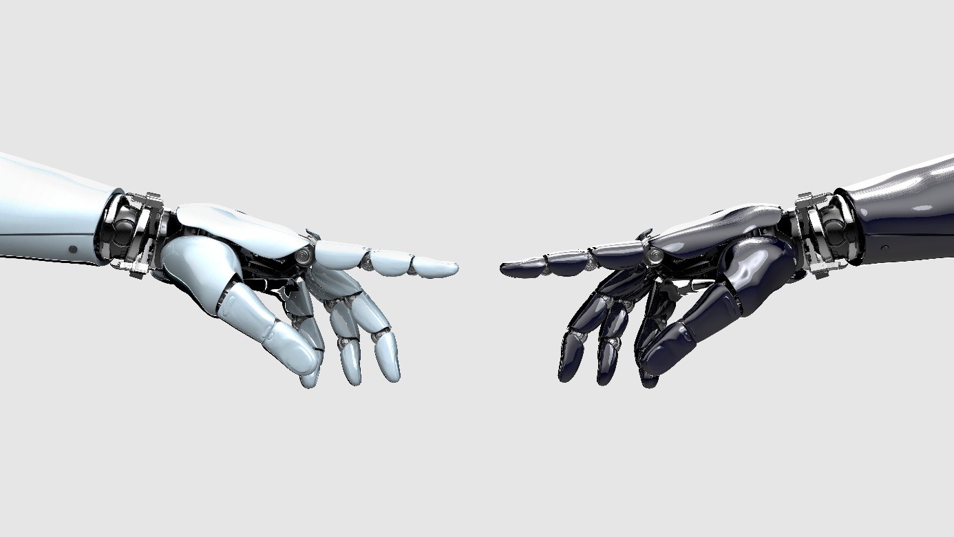 Zwei RoboterhÃ¤nde, die sich vor einem neutralen Hintergrund entgegenstrecken und damit den Fokus von ITVT auf die Zusammenarbeit zwischen Mensch und Technologie, auf Innovation und auf intelligente digitale LÃ¶sungen symbolisieren.